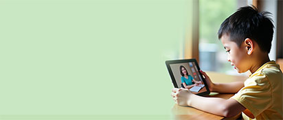 一个小男孩正在使用平板电脑和PSLE华文老师上中文课。